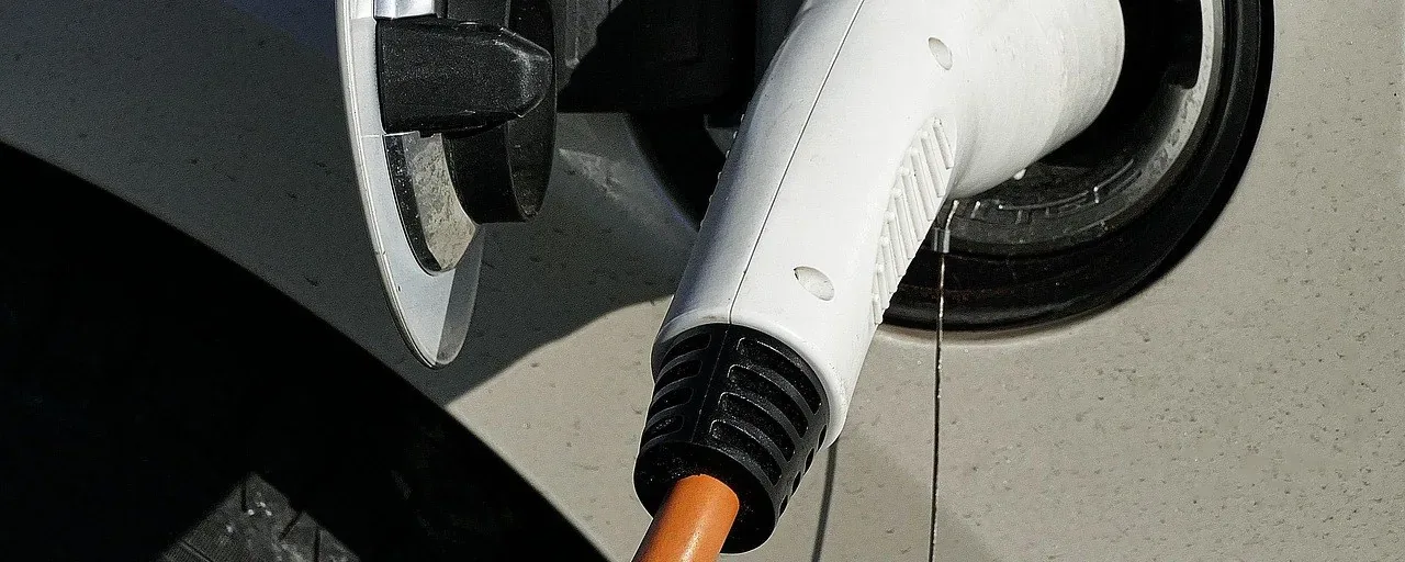 Laddkontakt med orange kabel ansluten till en elbil Laddkontakt med orange kabel ansluten till en elbil