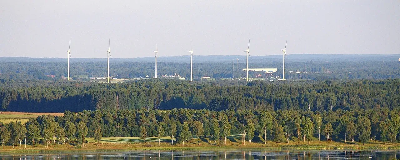Vindkraftverk över skog och vatten vid Falköping
